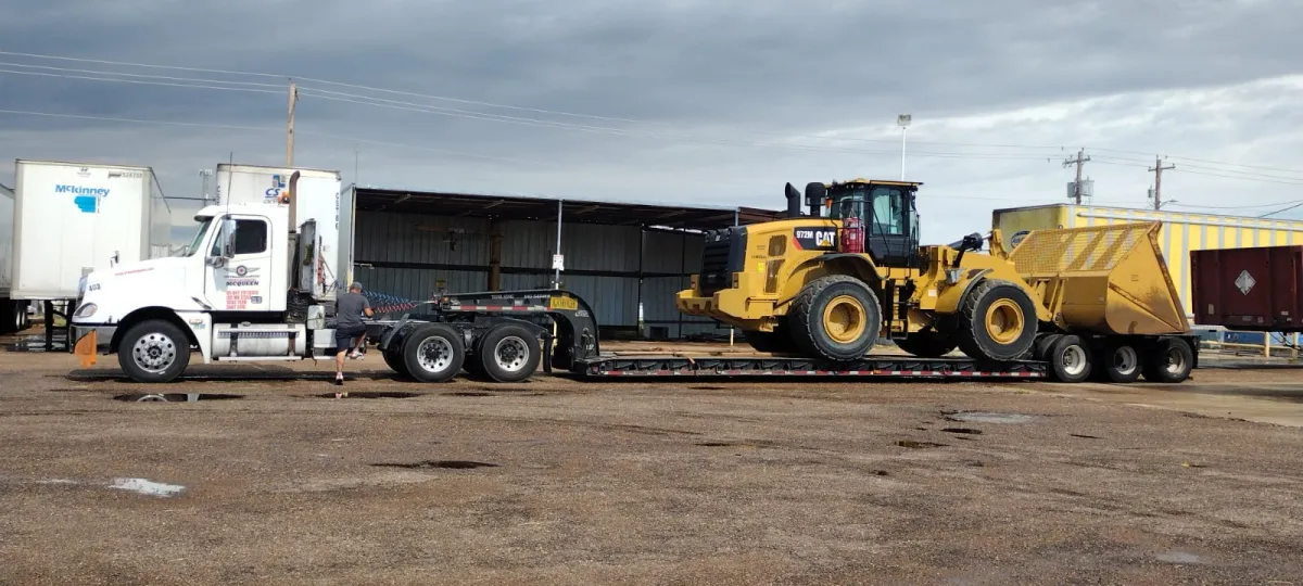 Lowboy trailer hauling a CAT wheel loader